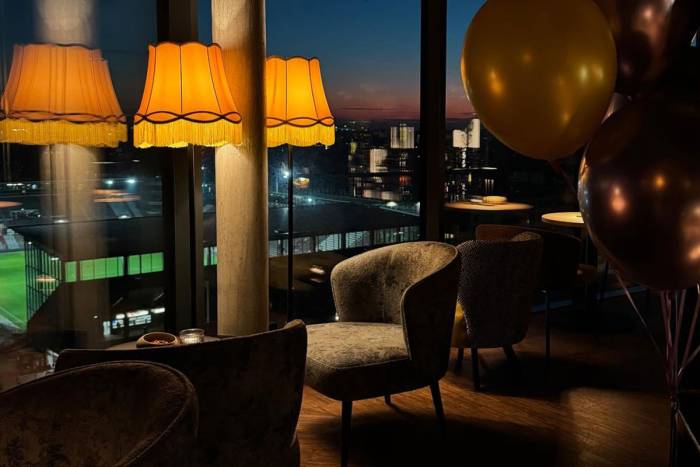 Besonderes Ambiente im KARO&PAUL mit gemütlichen Sitzecken, warmem Licht und Blick auf die Hamburger Skyline.