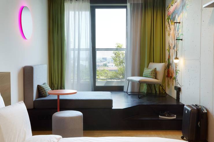 Sitzecke zum Entspannen mit atemberaubendem Blick auf Hamburg im Superior King Hotelzimmer im REVERB Hotel.