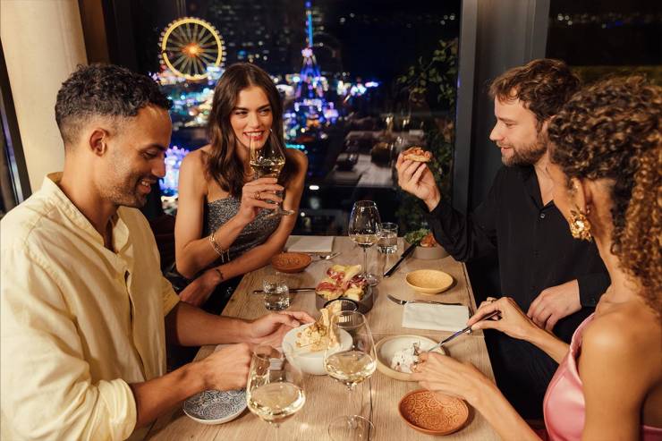 Freunde genießen gemeinsam ein Dinner im KARO&PAUL mit direktem Blick auf den Hamburger Dom!