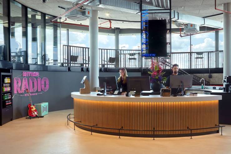 Runde, an den Panoramafenstern orientierte Raumgestaltung mit holzverkleideter Rezeption.