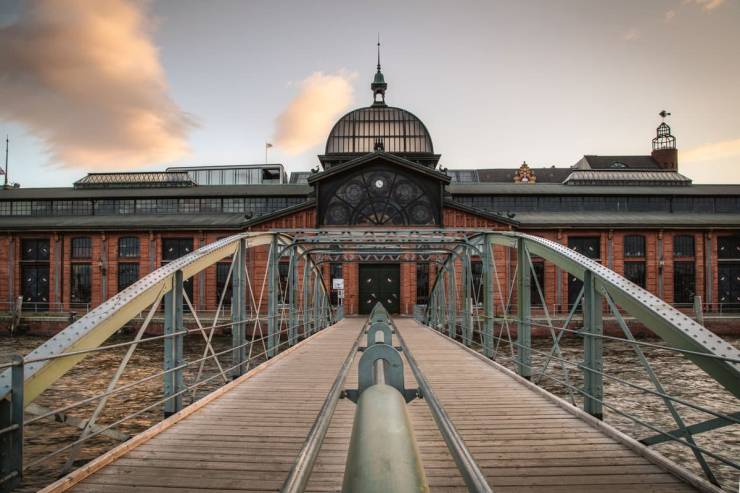 Altonaer Fischauktionshalle aus rotem Backstein, mit durchscheinender Kuppel und großzügigen Fenstern.