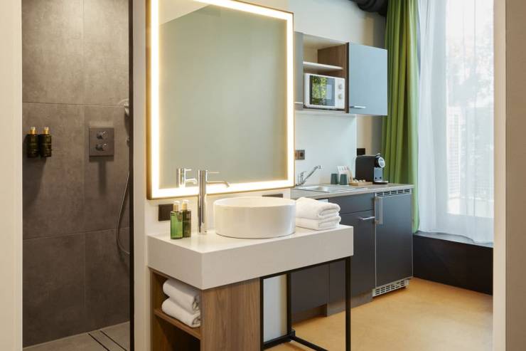 Gemütliche Ausstattung: Küchen-Ecke, Waschbecken mit Spiegel und Duschraum mit Industrial-Elementen.