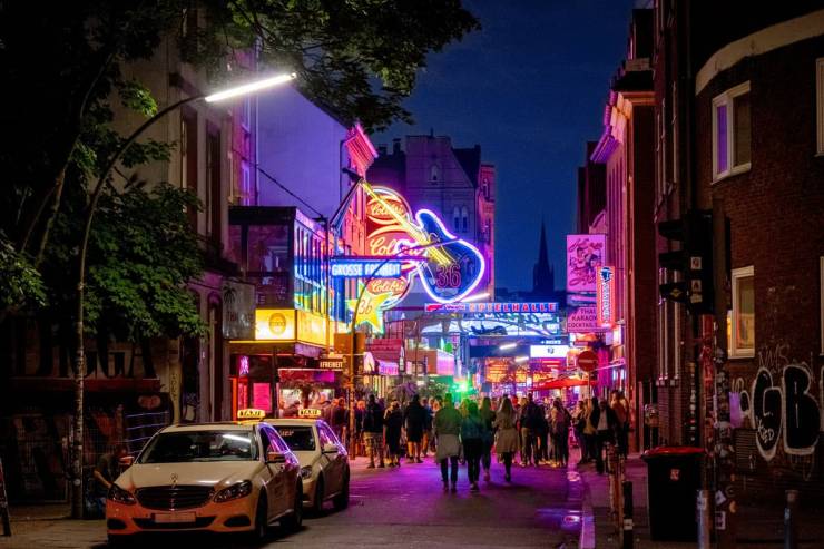 Hamburgs belebter Party-Kiez bei Nacht, mit seinen beleuchteten Club-Schildern.
