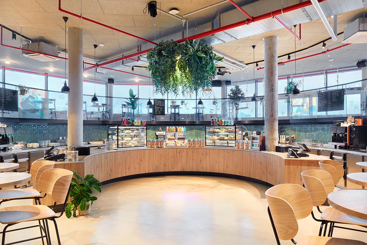 Einrichtung eines Cafés mit Elementen aus Industrial Chic und Naturmaterialien.