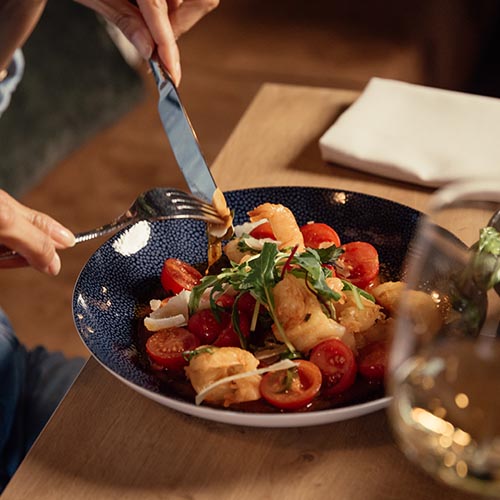 Eine vielseitige Auswahl kalter und warmer Speisen, dazu ein Glas Rotwein.