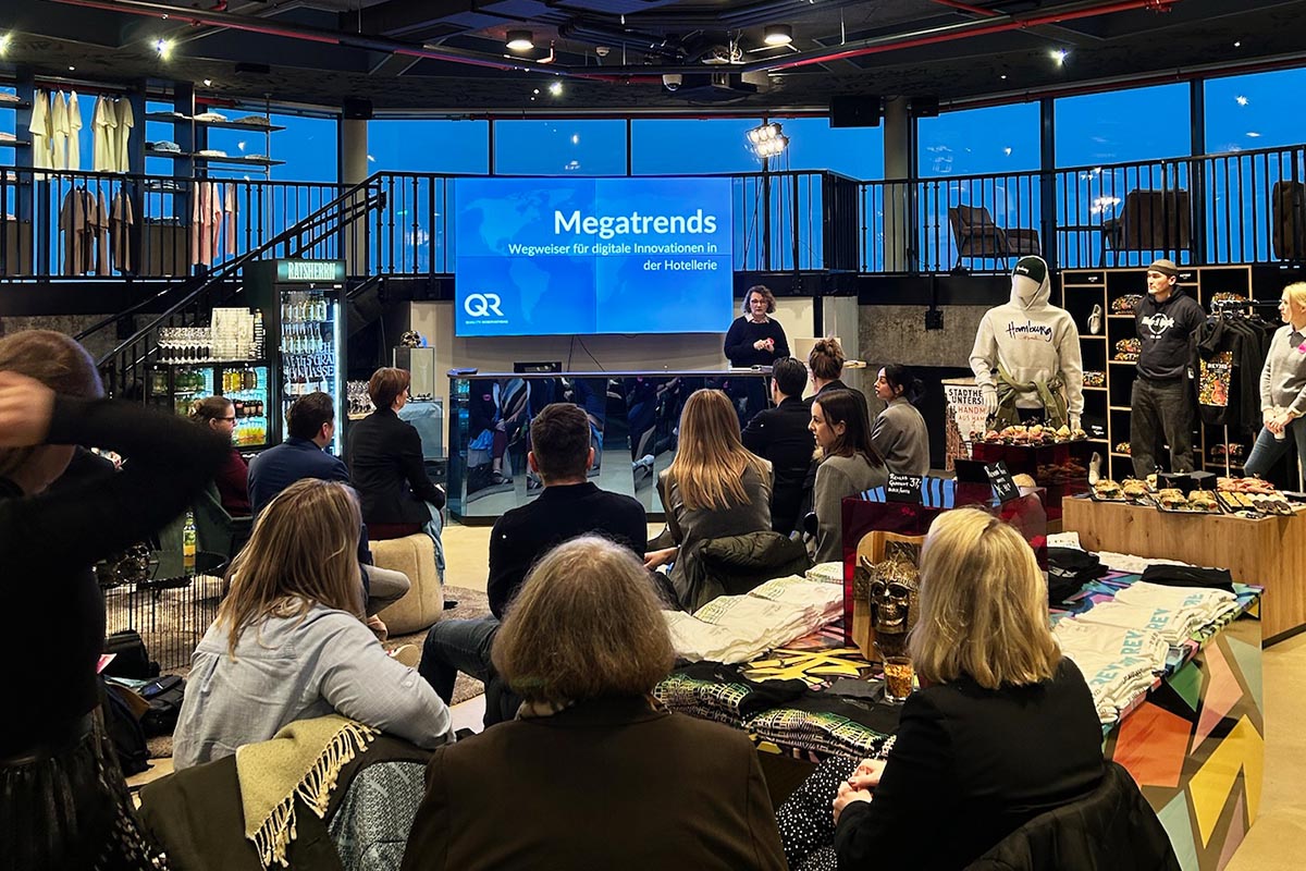 Live-Event im Rock Shop, bei dem Besucher einen Vortrag hören können, umgeben von Merchandising-Artikeln aus dem Shop.